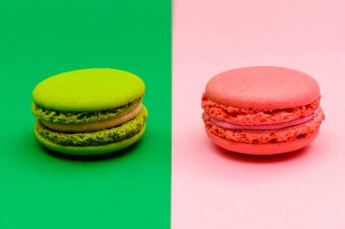 İki kağıt rengi arka planda iki renkli badem kurabiyesi.