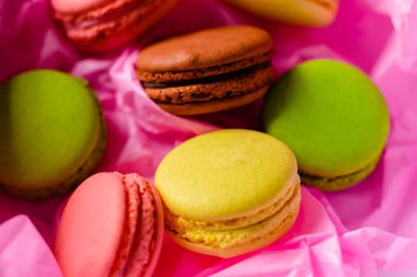 Pembe bir arka planda çok renkli badem kurabiyeleri.