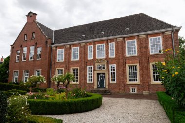 LEER, GERMANY - 11 Eylül 2025: Amtsgericht Leer 'in (Bölge Mahkemesi) tarihi cephesi, bulutlu bir gökyüzünün altında resmi bahçesi olan eski bir 18. yüzyıl malikanesi.