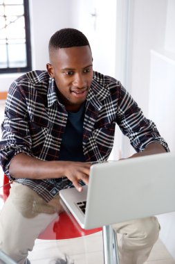 Adam evde dizüstü bilgisayarla çalışıyor.