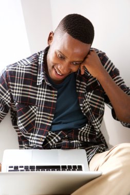 adam evde bir dizüstü bilgisayar kullanarak