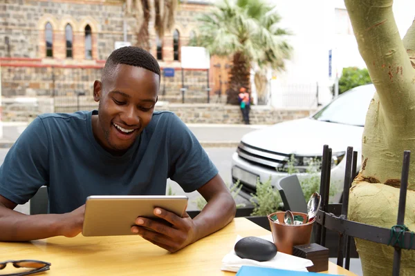 Chico alegre en la cafetería con una tableta digital — Foto de Stock