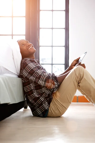 Glücklicher Mann sitzt mit Tablet zu Hause — Stockfoto