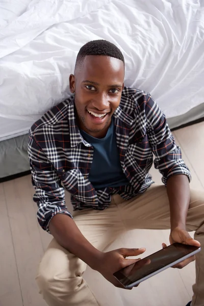 Jeune homme souriant avec tablette — Photo