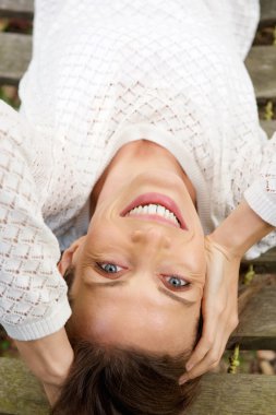 Beyaz kazaklı gülümseyen kadın