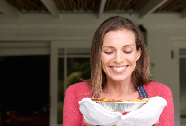 Smiling woman smelling freshly cook pie — Stock Photo, Image