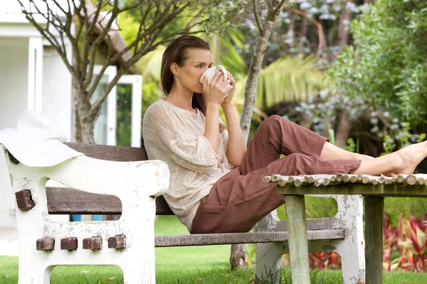 Woman drinking tea outside in backyard — Stock Photo, Image