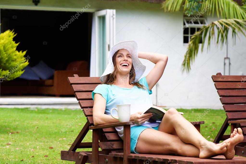 Older woman smiling with book outside