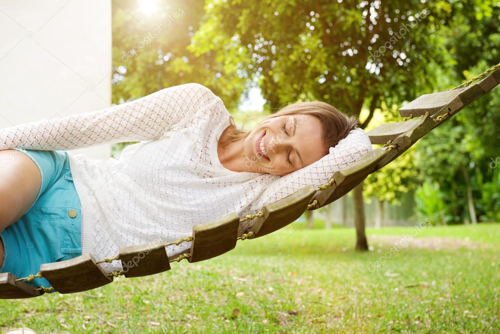 Smiling woman relaxing on hammock 