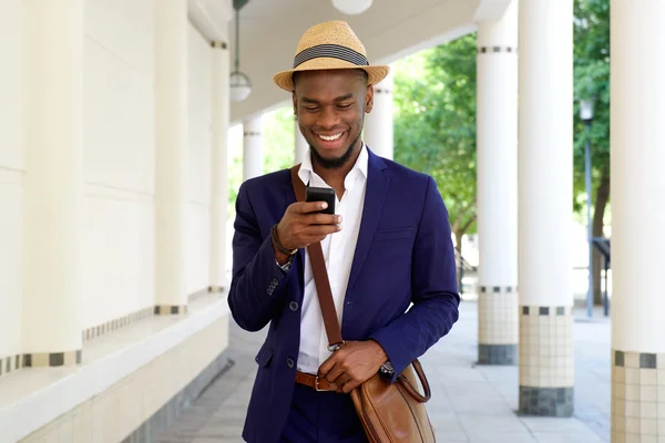 Młody człowiek afrykańskie wędrówki z cellphone — Zdjęcie stockowe
