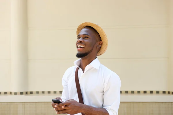 Счастливый молодой африканский мужчина с мобильным телефоном — стоковое фото