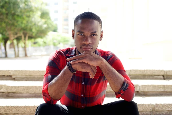 Young african man sitting on steps — Stock Photo, Image