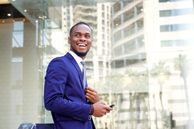 Mutlu genç işadamı şehirde ayakta 