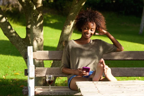 Femme noire souriante assise dans le parc — Photo