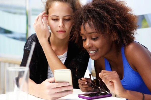 Twee vriendinnen kijken naar mobiel — Stockfoto