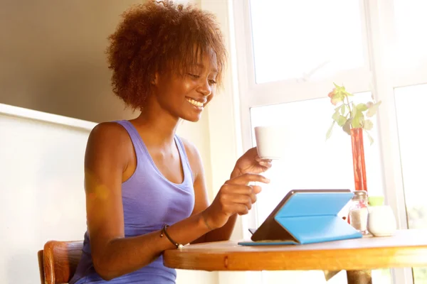 Sonriente joven mujer negra usando tableta digital — Foto de Stock