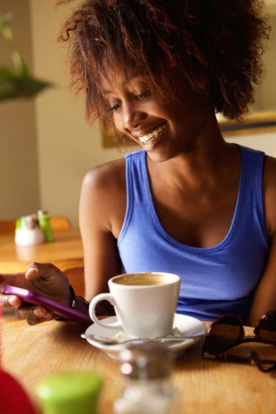 Lachende jonge zwarte vrouw met behulp van mobiele telefoon — Stockfoto