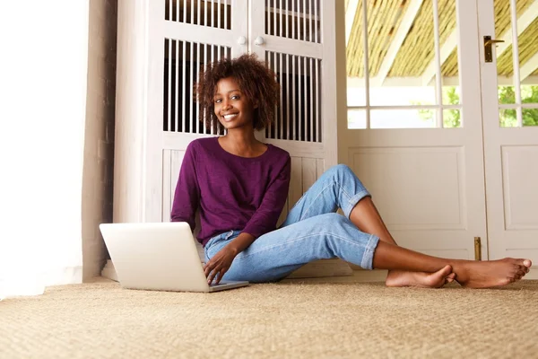 Lachende zwarte vrouw zitten met laptop — Stockfoto