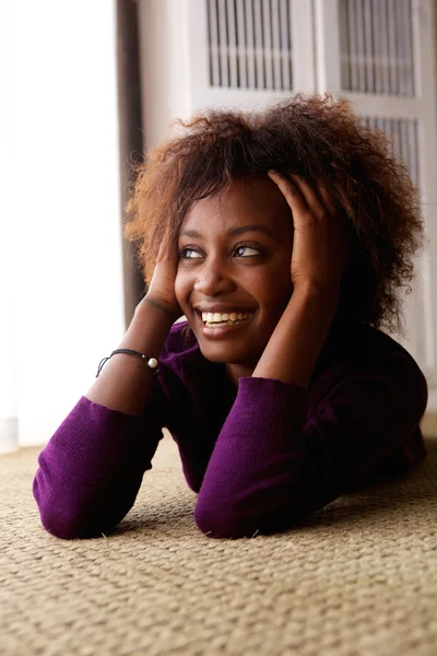 Mujer negra acostada en el suelo sonriendo — Foto de Stock