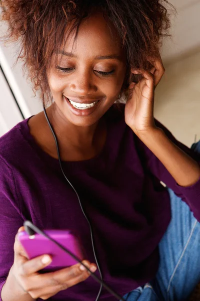 Smiling african woman listening to music — Stock Photo, Image