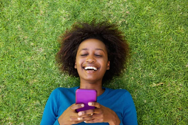 Lachende vrouw liggen op gras — Stockfoto