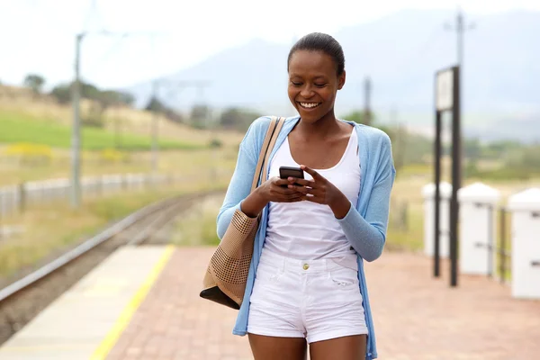 Mulher usando telefone celular na estação ferroviária — Fotografia de Stock