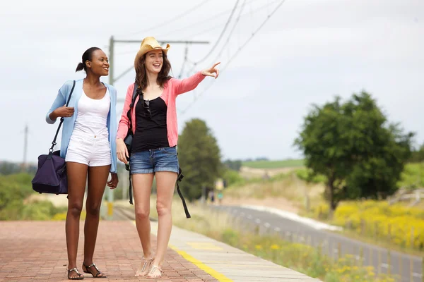 Twee vriendinnen lopen op railroad station — Stockfoto