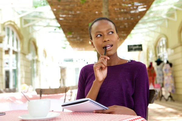 Mujer africana joven en la cafetería escribiendo notas — Foto de Stock