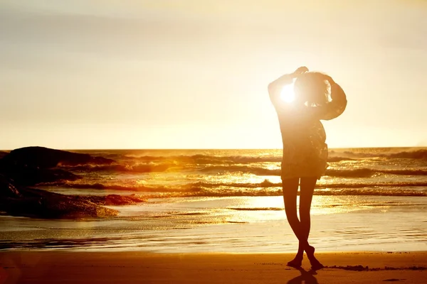 Silueta de mujer joven caminando en la playa — Foto de Stock