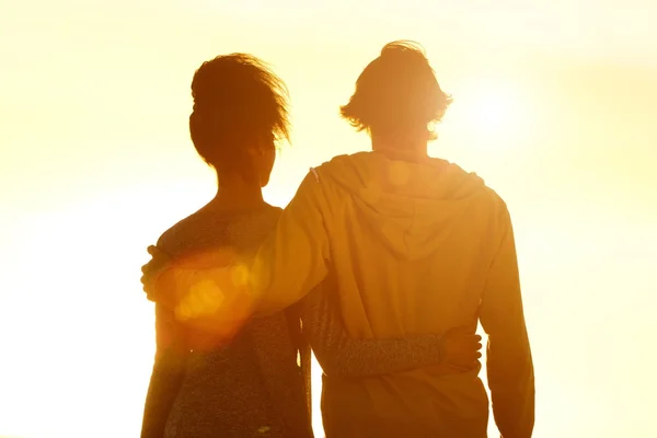 年轻夫妇拥抱看着日落 — 图库照片