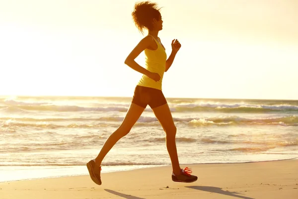 Donna fitness che corre via mare al tramonto — Foto Stock