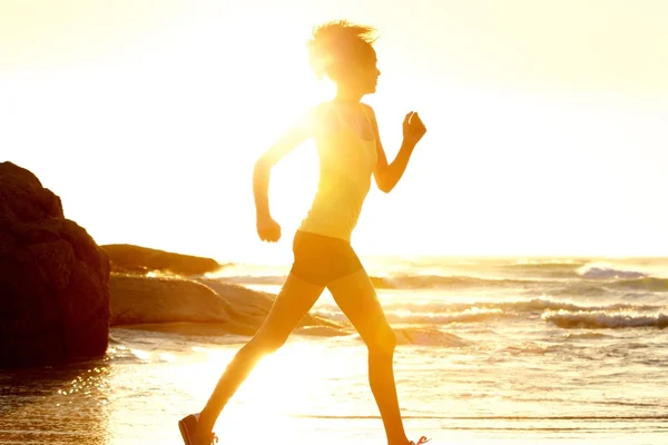 Female runner by the sea during sunset — Stock Photo, Image