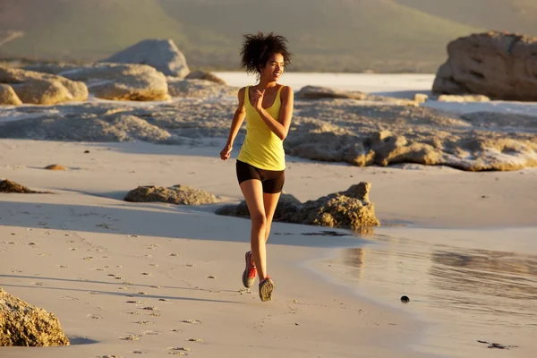 Young woman running on the beach — Stock Photo, Image