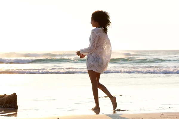 Frau geht am Strand spazieren — Stockfoto