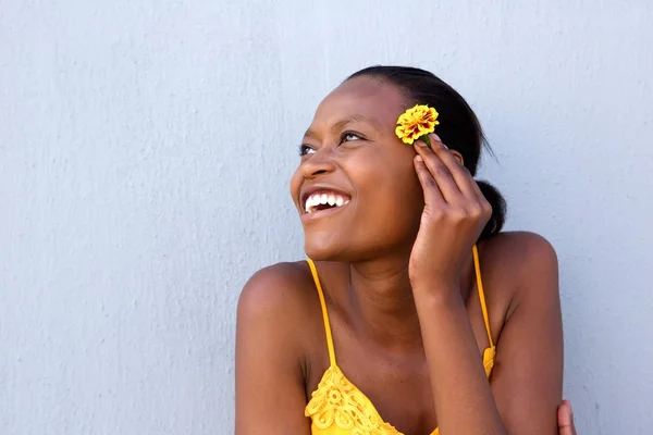 Sorrindo jovem senhora africana segurando uma flor — Fotografia de Stock