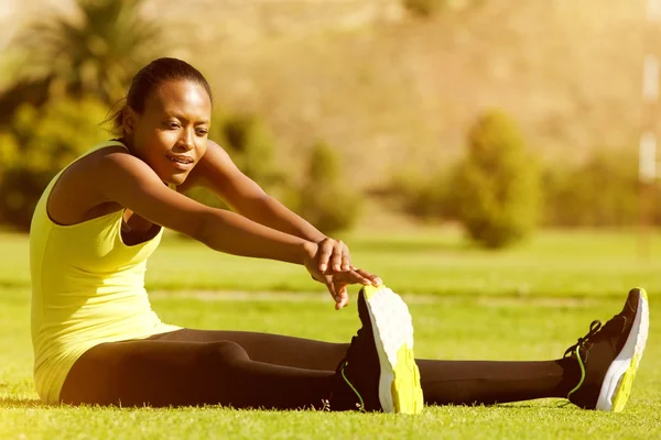 年轻的健身女跑步运动员伸展双腿 — 图库照片