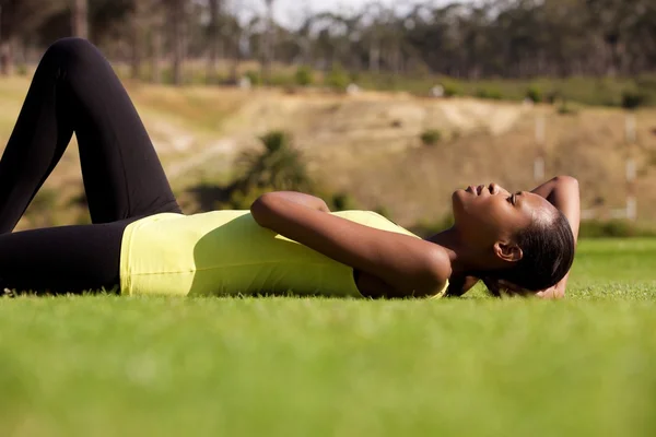 Молодая спортсменка лежит на траве — стоковое фото