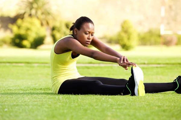 Junge Afrikanerin sitzt auf Gras — Stockfoto