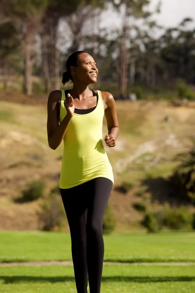 Happy black woman running in park — Stock Photo, Image