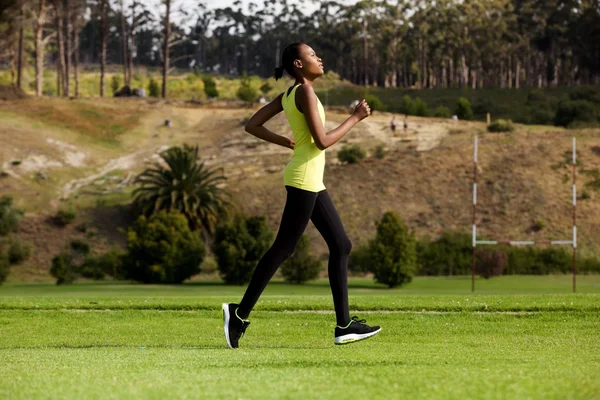 Mujer joven corriendo al aire libre en un parque — Foto de Stock