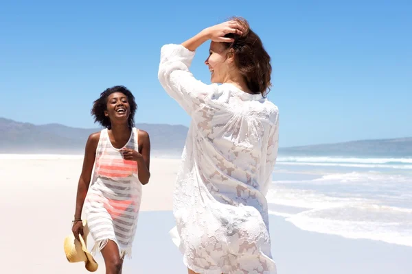 Twee jonge vrouwen vrienden spelen op het strand — Stockfoto