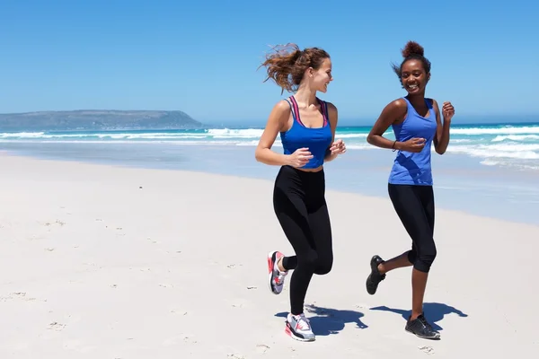 Dos jóvenes corriendo en la orilla del mar — Foto de Stock