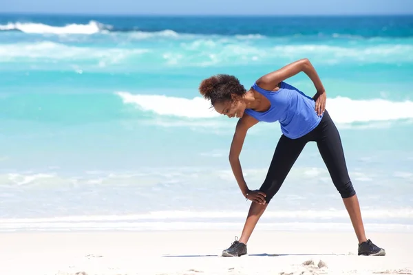 Mujer africana joven haciendo ejercicio en la playa — Foto de Stock