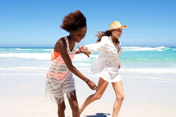 Jovens amigas felizes correndo na praia — Fotografia de Stock