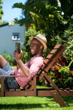 Dijital tablet kullanarak gülümseyen genç adam