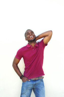 Başının arkasında el ile gülen genç adam 