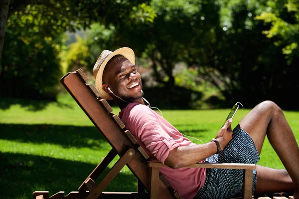 Jovem feliz relaxando na cadeira — Fotografia de Stock