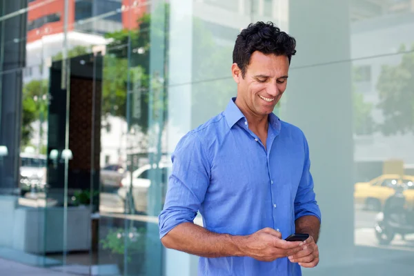 Uomo d'affari a piedi con il telefono cellulare — Foto Stock