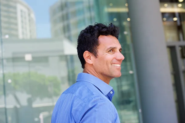 Sonriente hombre guapo caminando afuera en la ciudad — Foto de Stock