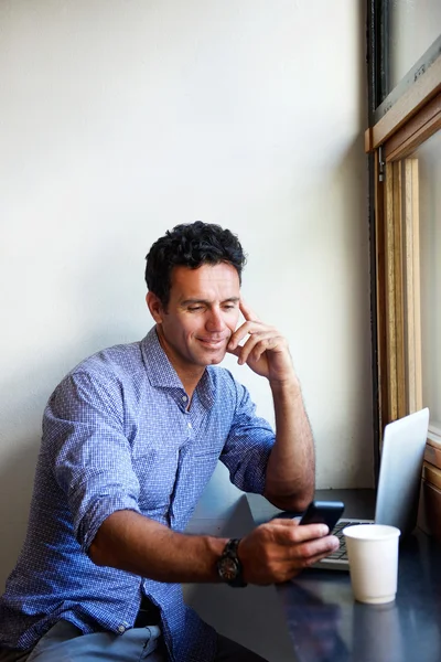 Man met laptop en mobiele telefoon winkels — Stockfoto